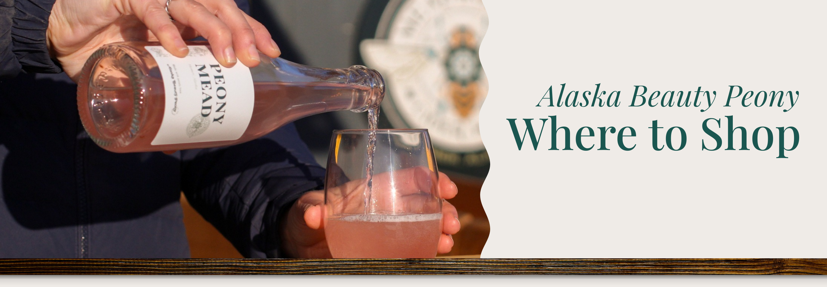 Person pouring a drink from a bottle labeled 'Alaska Beauty Peony' into a glass, with text about where to shop for the product | Alaska Beauty Peony Cooperative | Homer, AK